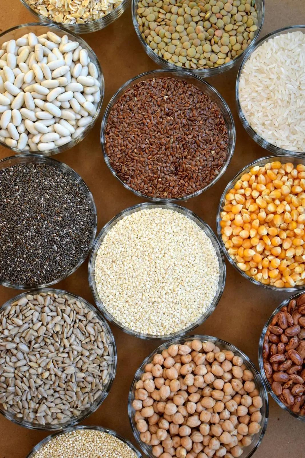 Glass jars of beans, lentils, seeds and grains seen from above